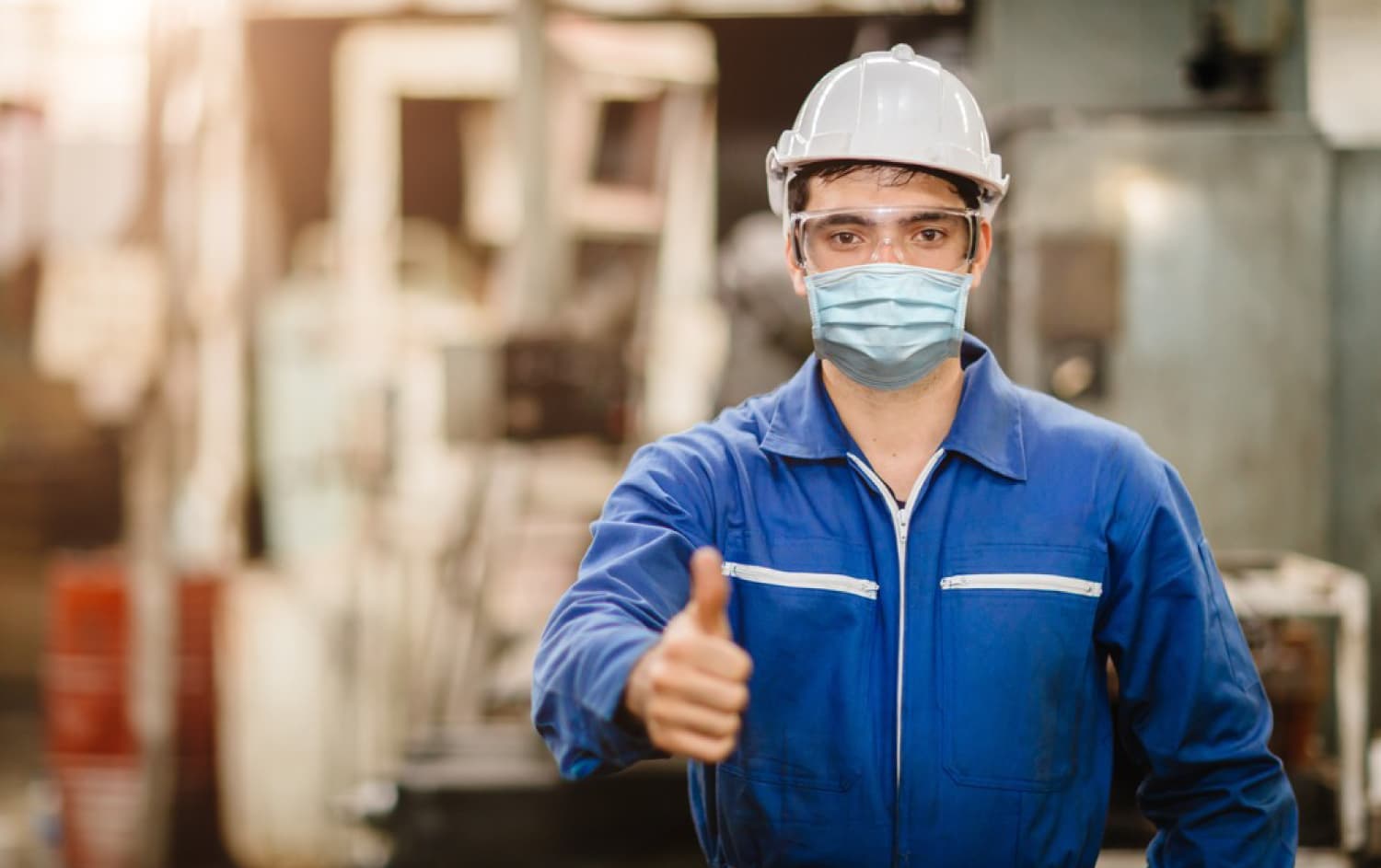 Operario con casco y equipo de protección en una planta industrial